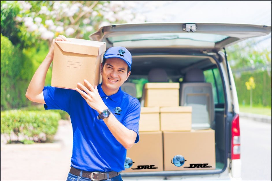 A delivery boy in blue carrying a box